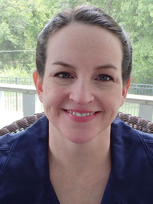 Smiling woman with brown hair pulled back into a bun