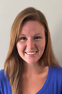 White woman with red hair wearing a blue shirt