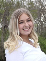 Blonde girl with blue eyes smiling wearing white shirt