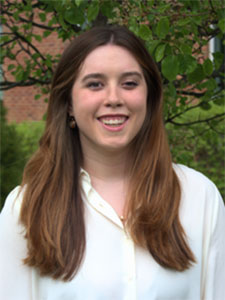 woman with brown hair wearing a grey suit jacket