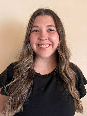 White woman with long brown hair wearing a black shirt