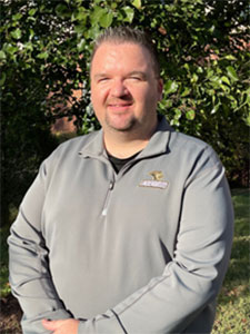 man with salt and pepper hair wearing a burgundy polo