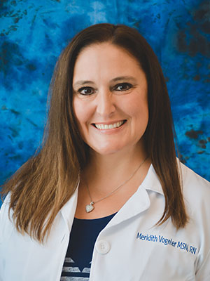 Woman with brown hair wearing a lab coat