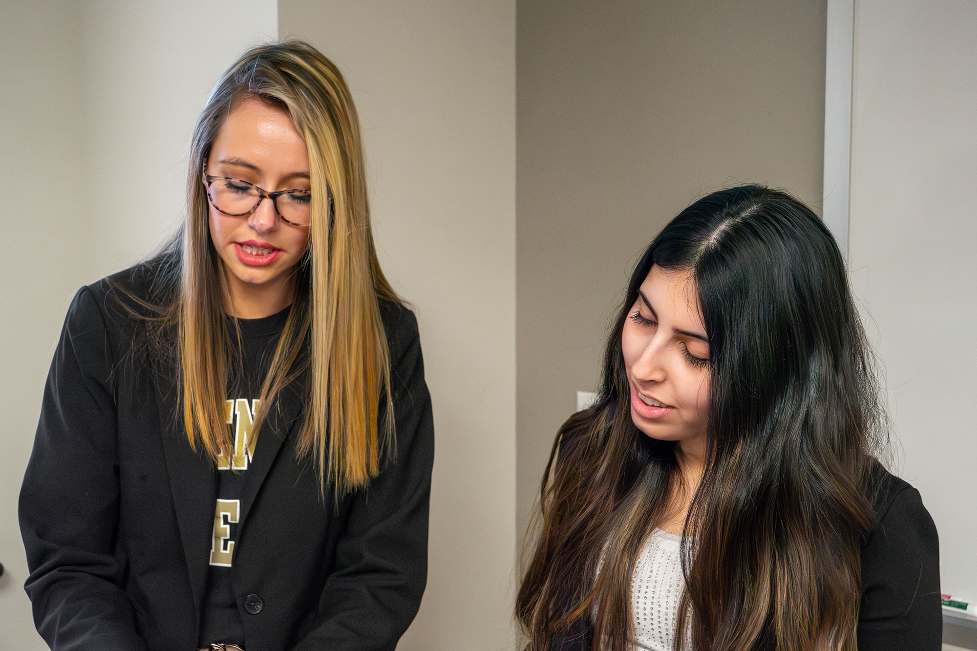 Two women in Harmon hall speaking