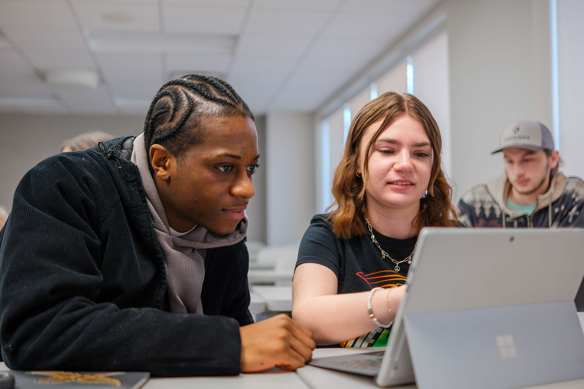 two students in class on laptop