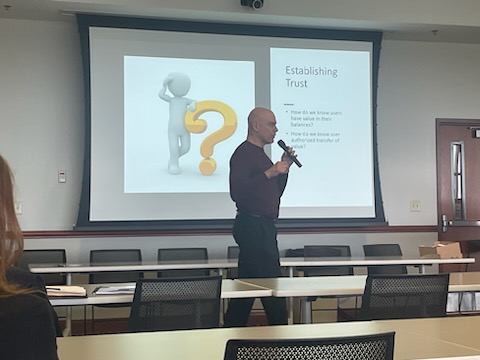 Presenter speaking in front of group.